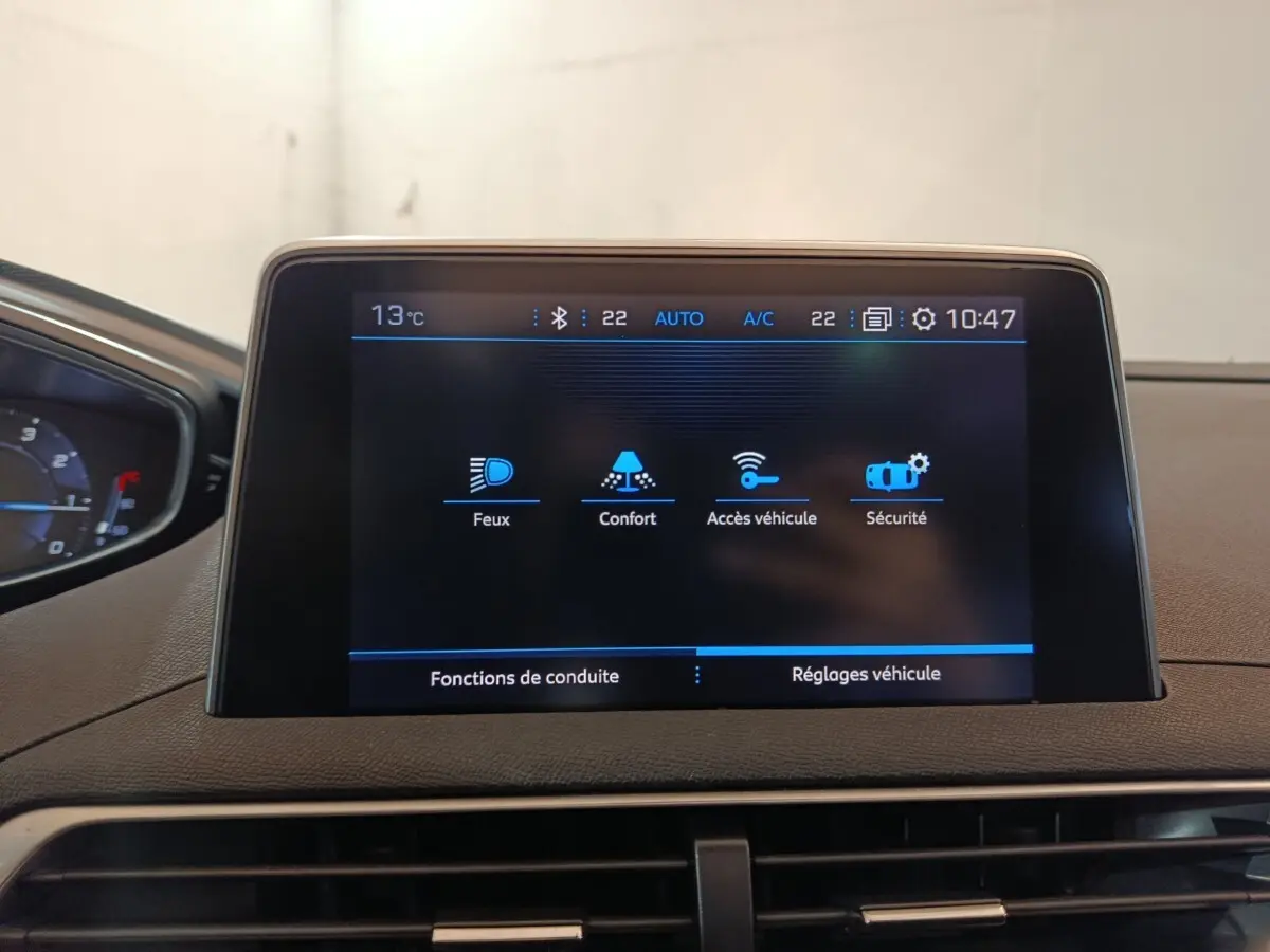 Écran tactile central affichant les réglages du véhicule dans l'habitacle d'un Peugeot 3008 blanc, vue de face.