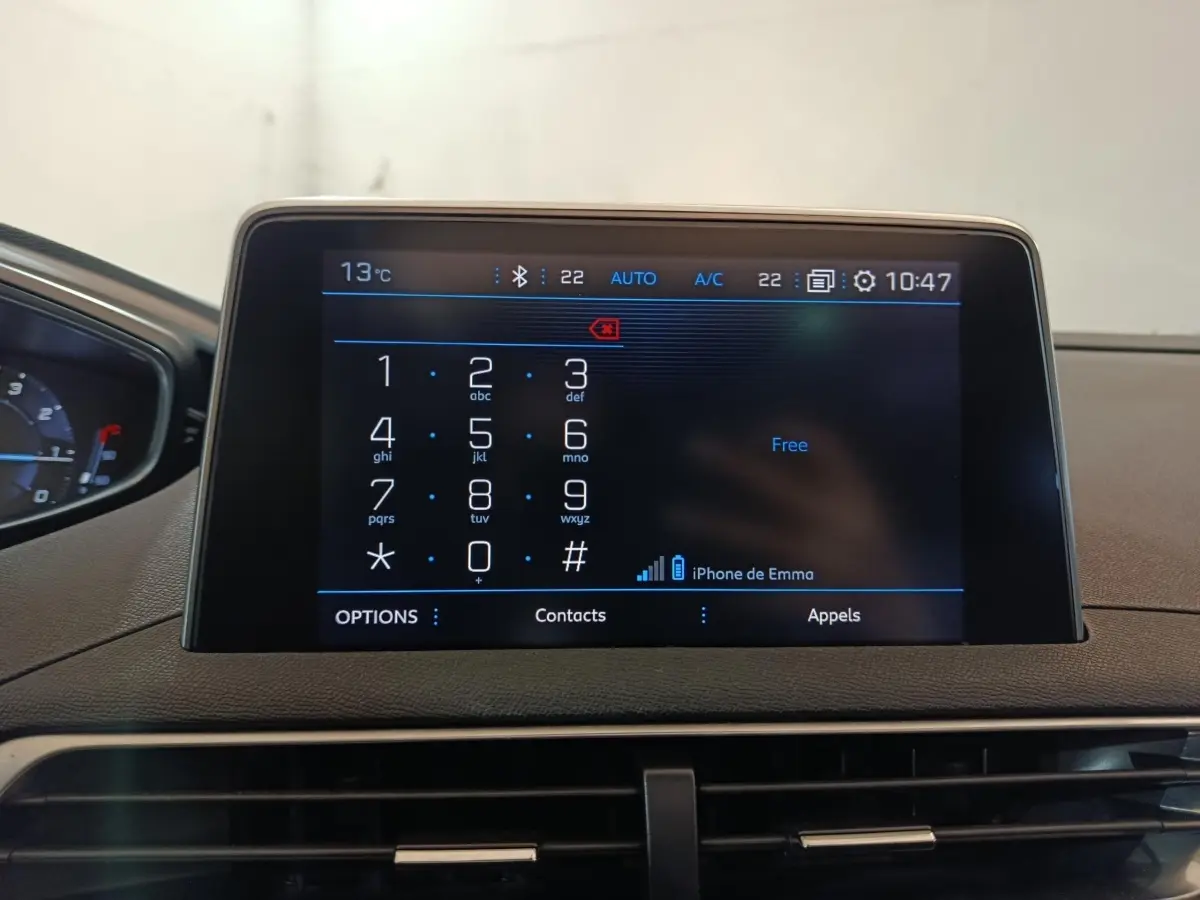 Écran tactile central affichant le clavier téléphonique dans l’habitacle d’un Peugeot 3008 blanc, vue de face.