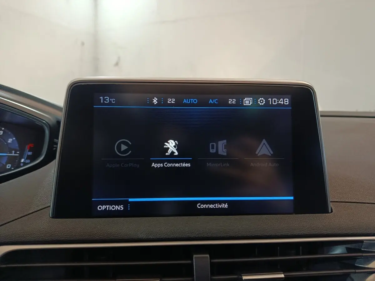 Écran tactile central affichant les options de connectivité dans l’habitacle du Peugeot 3008 blanc, vue de face.