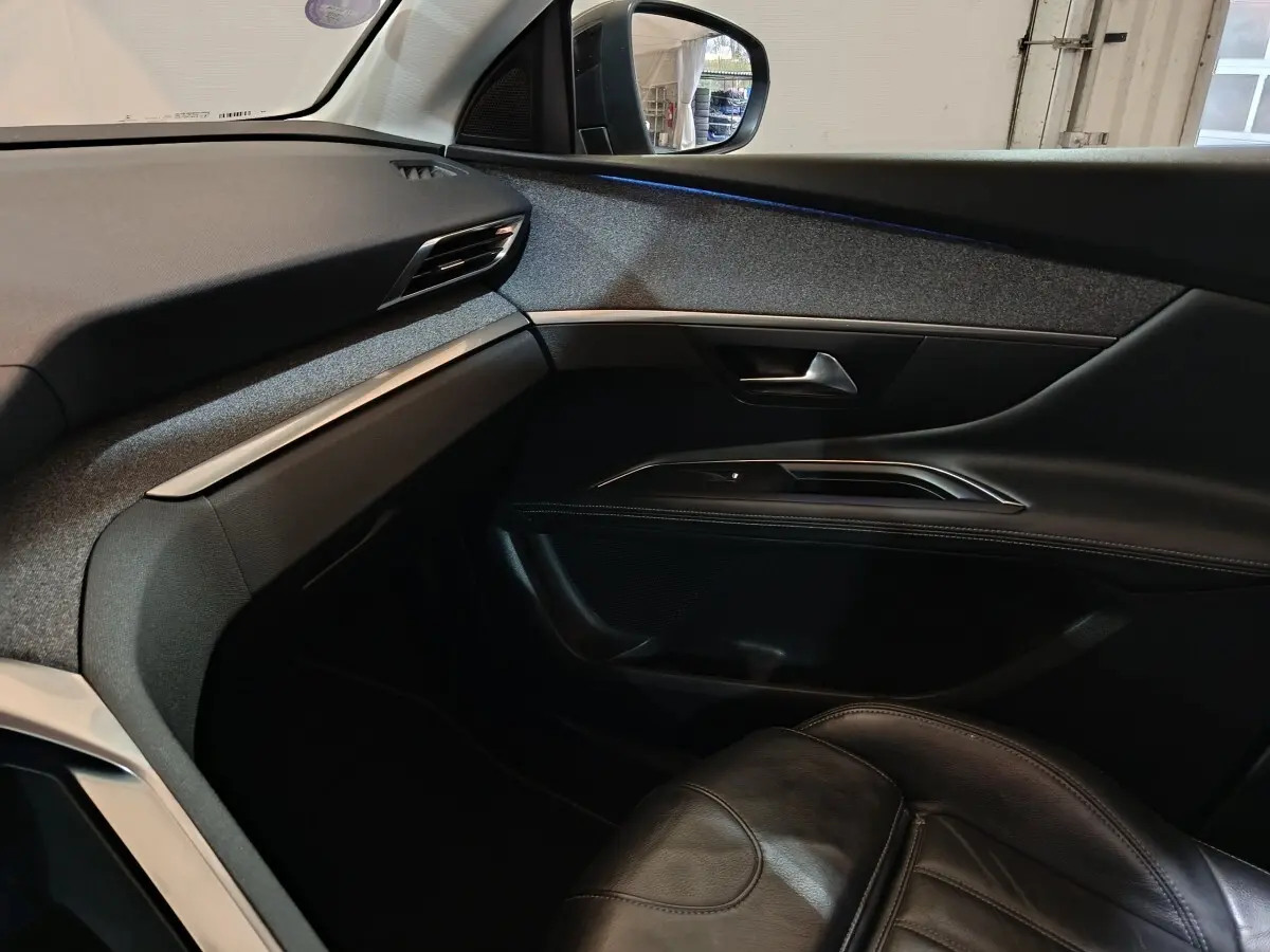 Vue intérieure côté passager du Peugeot 3008 blanc, mettant en valeur la porte et le siège en cuir noir.