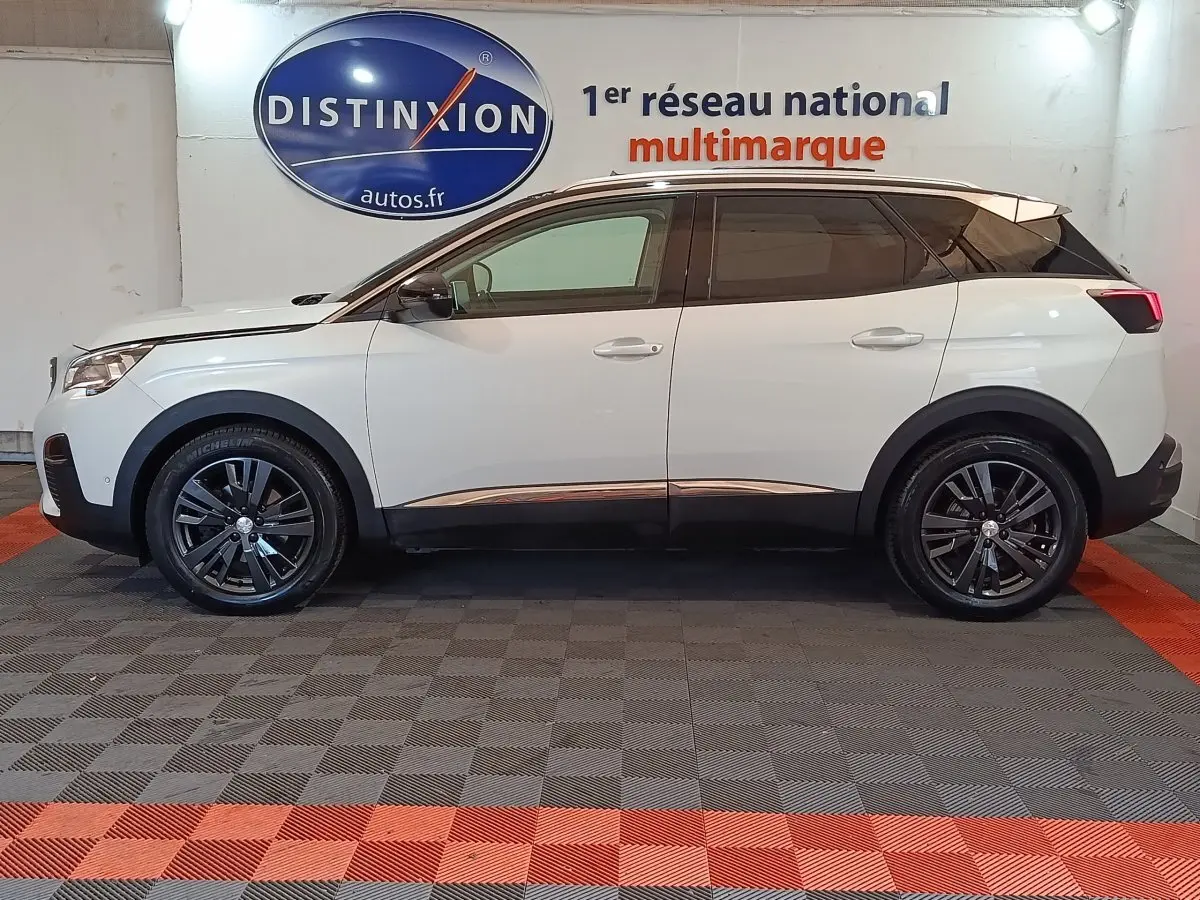 Profil droit d’un Peugeot 3008 blanc de 2019 en version Puretech Allure, avec jantes noires et toit noir contrastant.