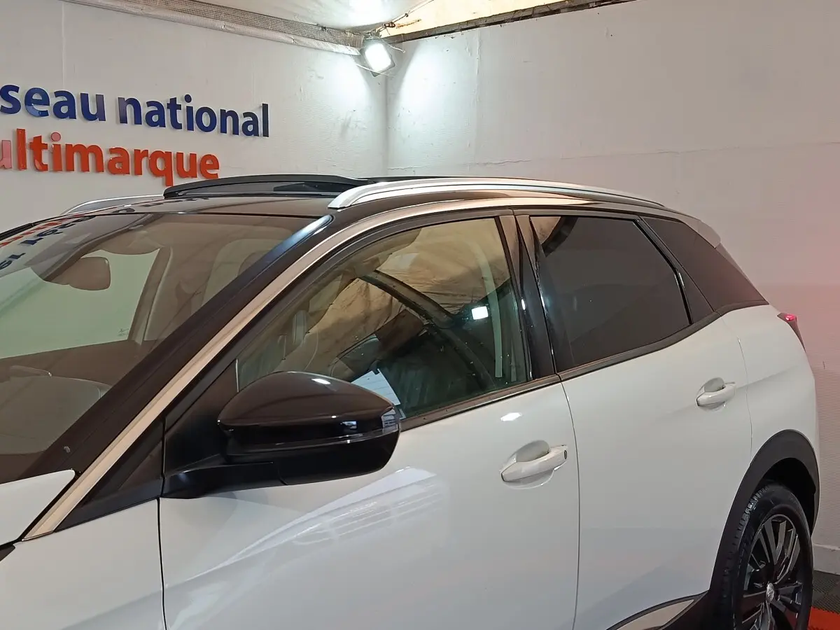 Vue latérale droite d’un Peugeot 3008 blanc avec rétroviseur noir et toit ouvrant panoramique visible.