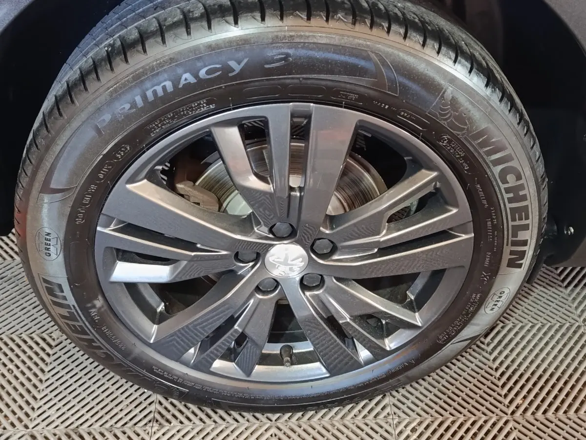 Gros plan sur la roue avant droite du Peugeot 3008 blanc, jante alliage gris foncé et pneu Michelin Primacy 3.