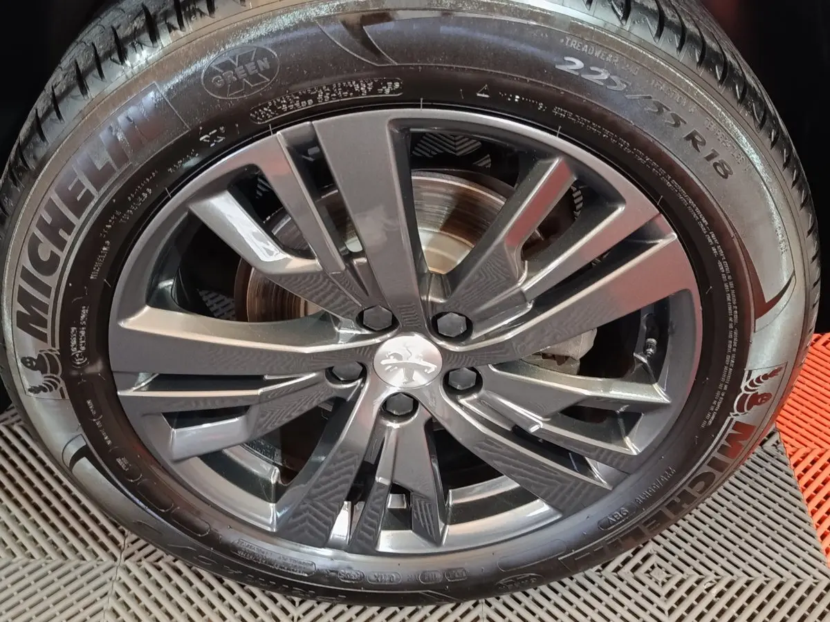 Gros plan sur la jante alliage grise et le pneu Michelin d’un Peugeot 3008 blanc, vue latérale.
