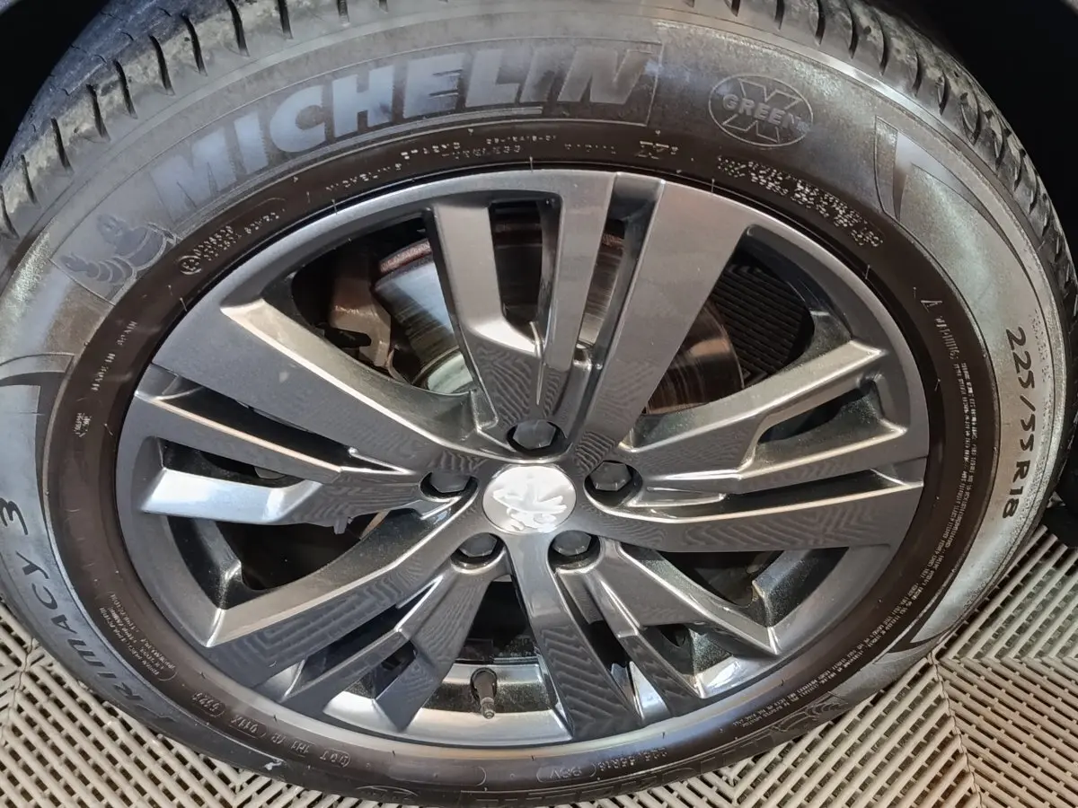 Gros plan sur la jante alliage grise et pneu Michelin d’un Peugeot 3008 blanc, vue latérale rapprochée.