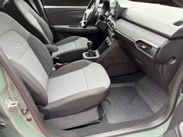 Vue intérieure côté droit de la Dacia Sandero Stepway 2025 kaki lichen, montrant les sièges et la boîte manuelle.