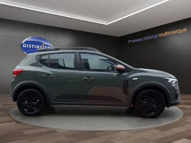 Vue de profil côté gauche d'une Dacia Sandero Stepway 2025 kaki lichen avec jantes noires et rétroviseurs marron.