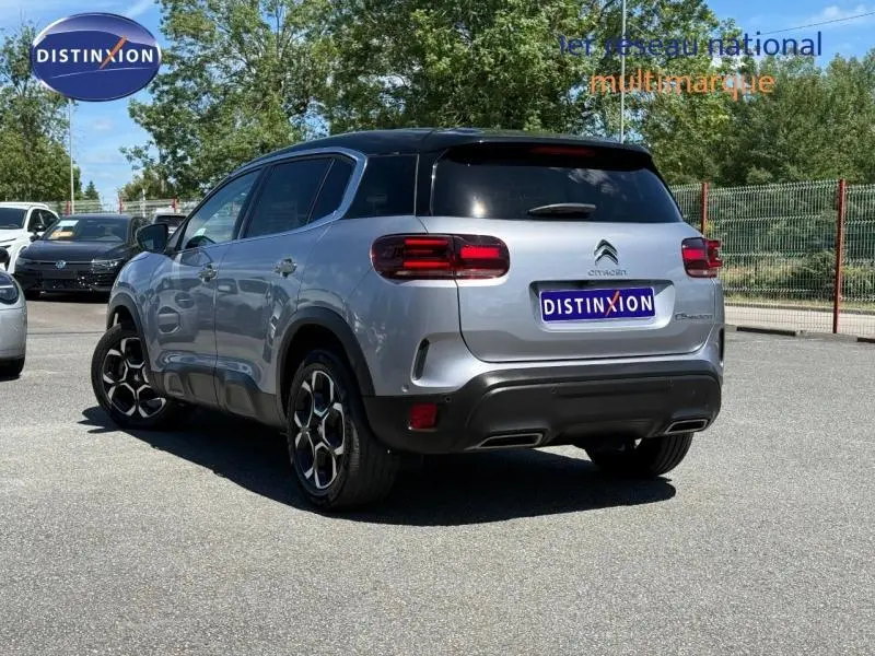 Vue 3/4 arrière droite du Citroën C5 Aircross gris acier avec toit noir et jantes alu distinctives.