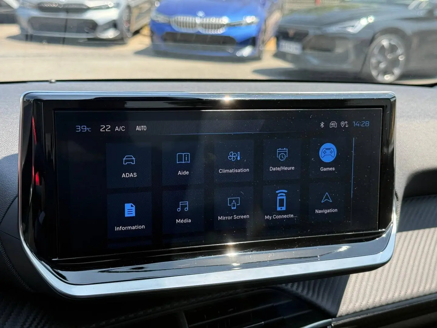 Écran tactile multifonction du tableau de bord de la Peugeot 208 gris Artense, avec menu affiché en intérieur.