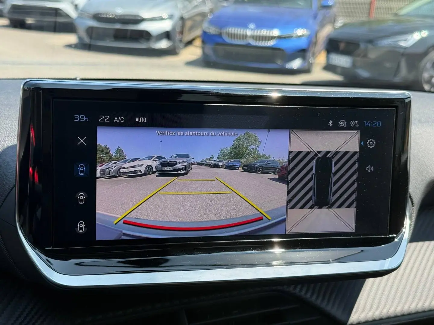 Écran tactile intérieur de la Peugeot 208 1.2 100ch Allure montrant la caméra de recul avec vue arrière et capteurs.