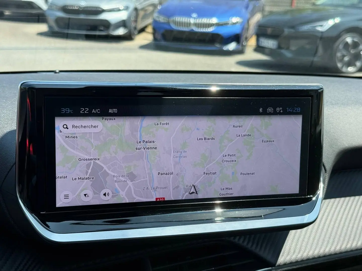 Vue intérieure centrée sur l'écran tactile du système de navigation du Peugeot 208 gris Artense 2025.