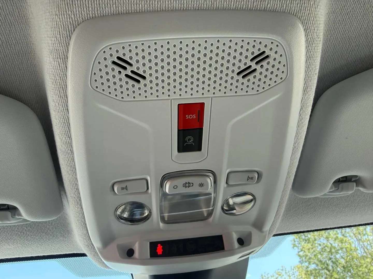 Vue en contre-plongée du plafonnier gris clair avec bouton SOS rouge dans l’habitacle d’une Peugeot 208 2025.