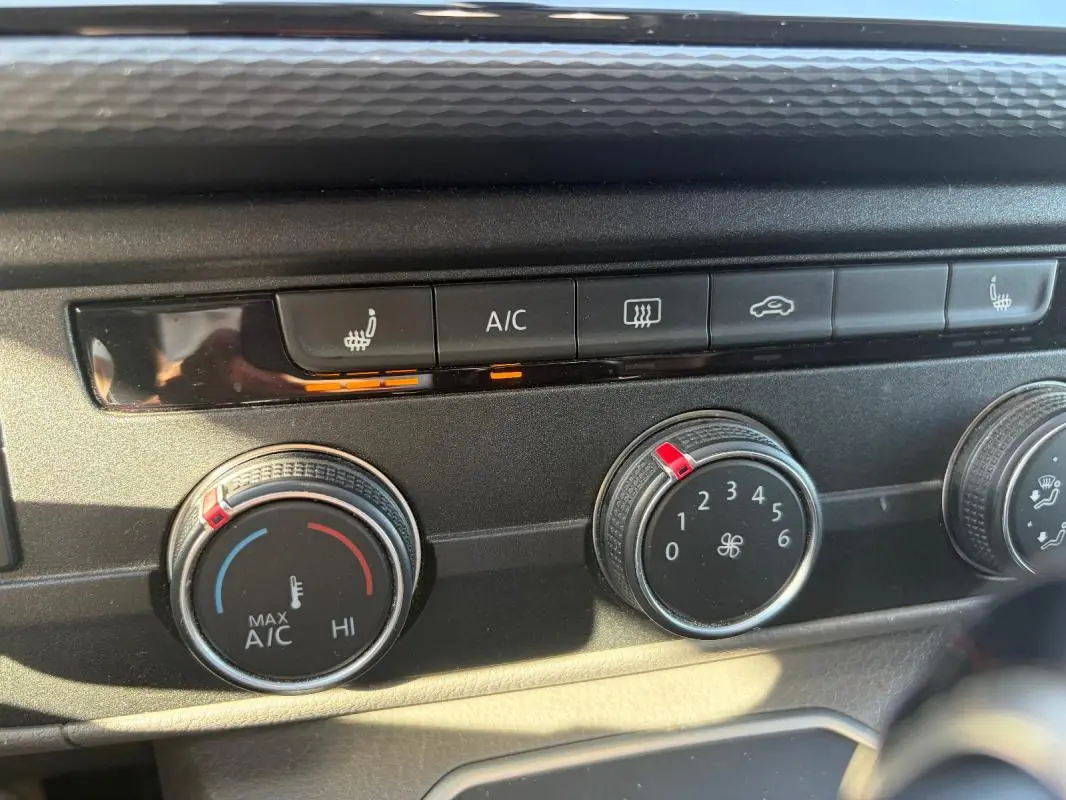 Gros plan sur les commandes de climatisation et sièges chauffants du Volkswagen Transporter blanc, version 2020.