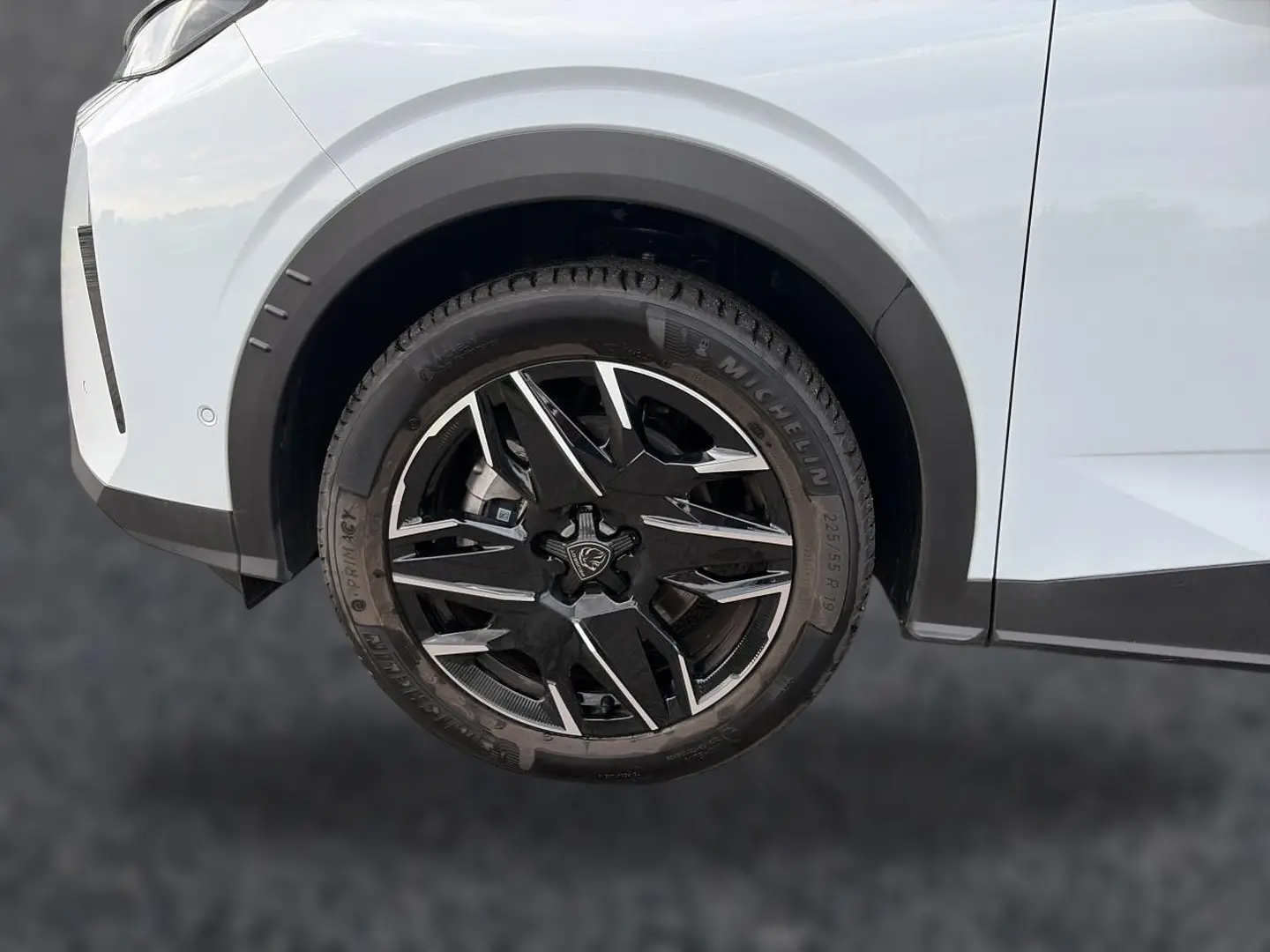 Gros plan sur la roue avant droite noire et argentée du Peugeot 5008 blanc Hybrid 145 allure e-dcs6 2025.