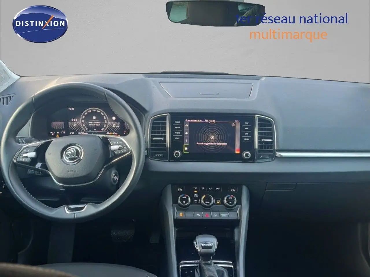 Intérieur moderne du Skoda Karoq 2023, vue frontale du tableau de bord avec écran tactile et volant multifonction noir.