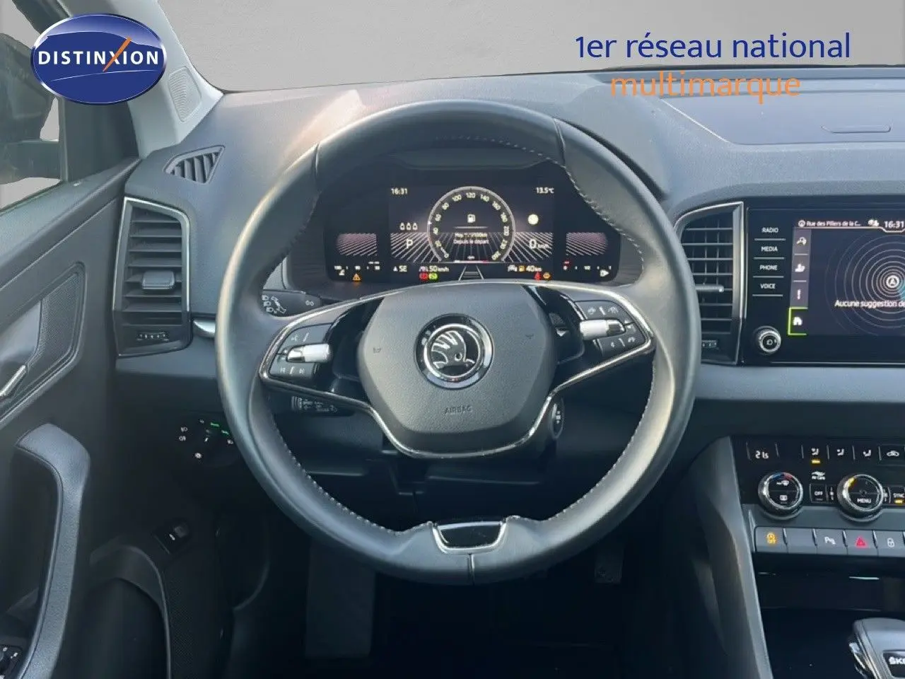 Vue intérieure centrée sur le volant et le tableau de bord numérique d'une Skoda Karoq noir Magic Metal 2023.