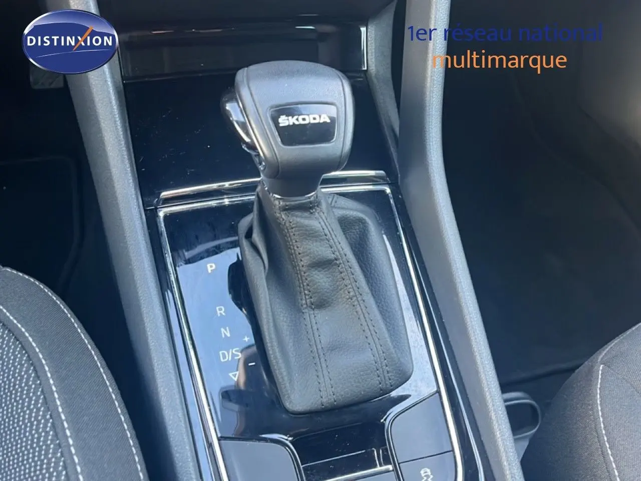 Le levier de vitesses automatique Skoda KAROQ 1.5 TSI noir, vue rapprochée de la console centrale intérieure.