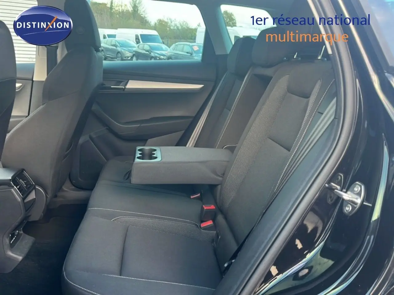 Intérieur arrière du Skoda Karoq noir Magic Metal, vue côté droit avec accoudoir central et porte ouverte.