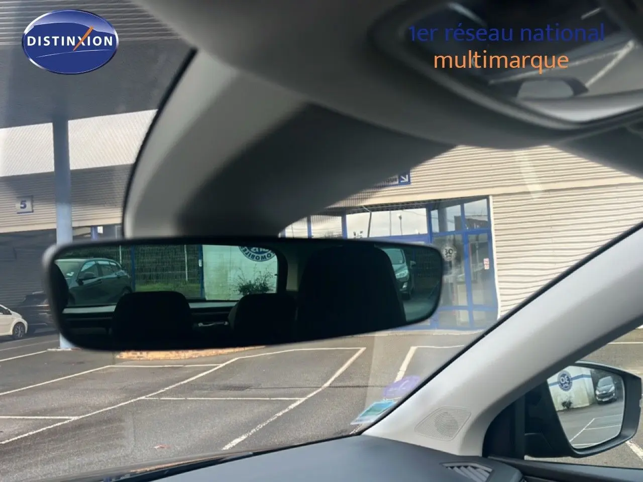 Vue intérieure du poste de conduite du Skoda Karoq noir Magic Metal, avec rétroviseur central et extérieur visibles.