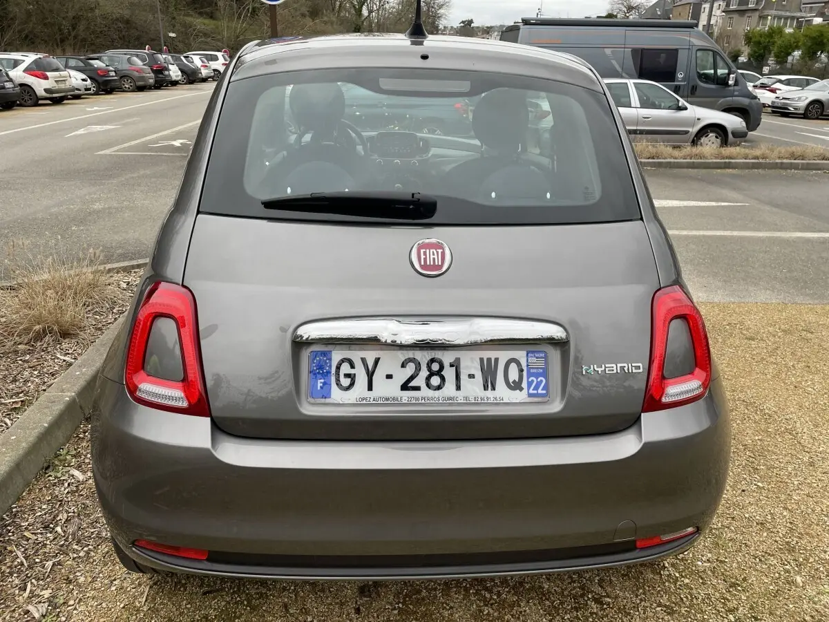 Vue arrière d'une Fiat 500 hybride gris foncé avec feux arrière rouges et plaque d'immatriculation française visible.