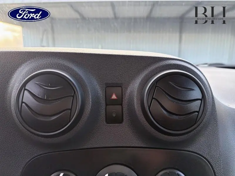 Détail du tableau de bord avec deux aérateurs ronds noirs et boutons de verrouillage, intérieur d’un Mercedes Citan blanc.