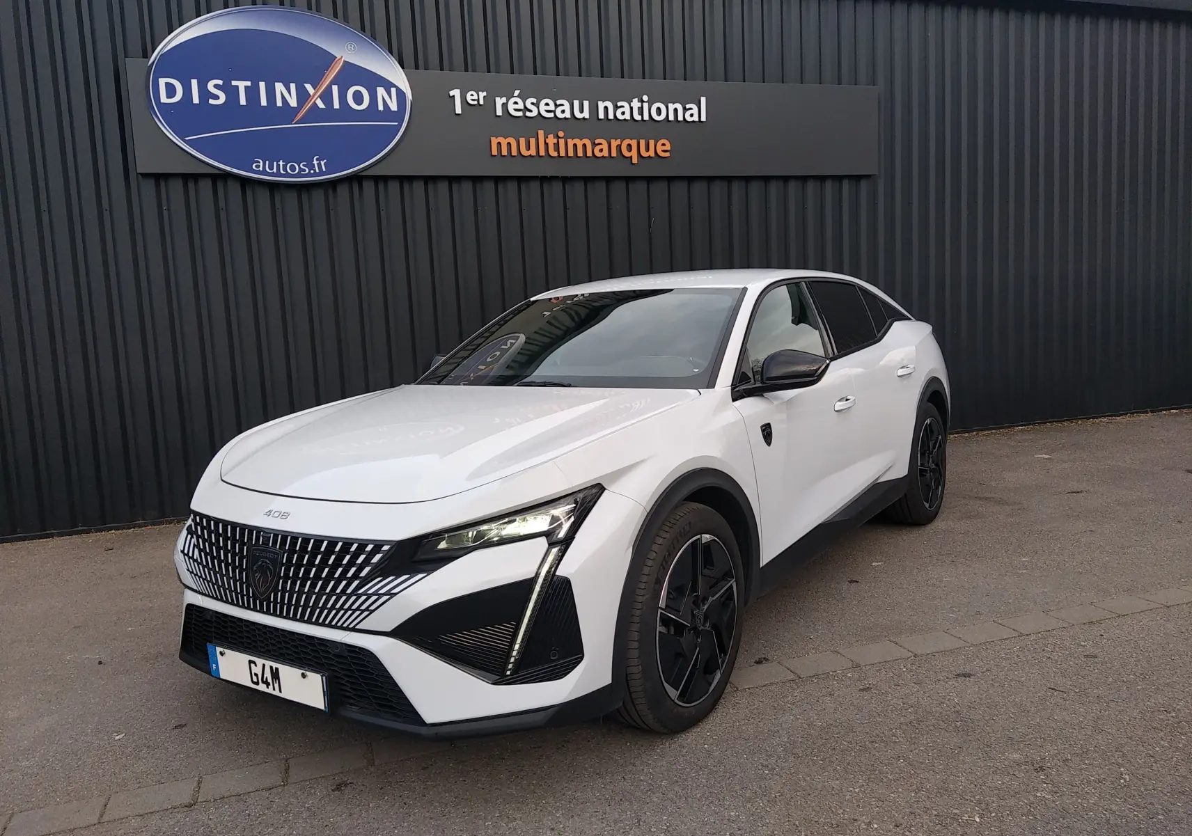 Peugeot 408 Hybrid blanc Okenite vue 3/4 avant droit, avec calandre distinctive et jantes noires.