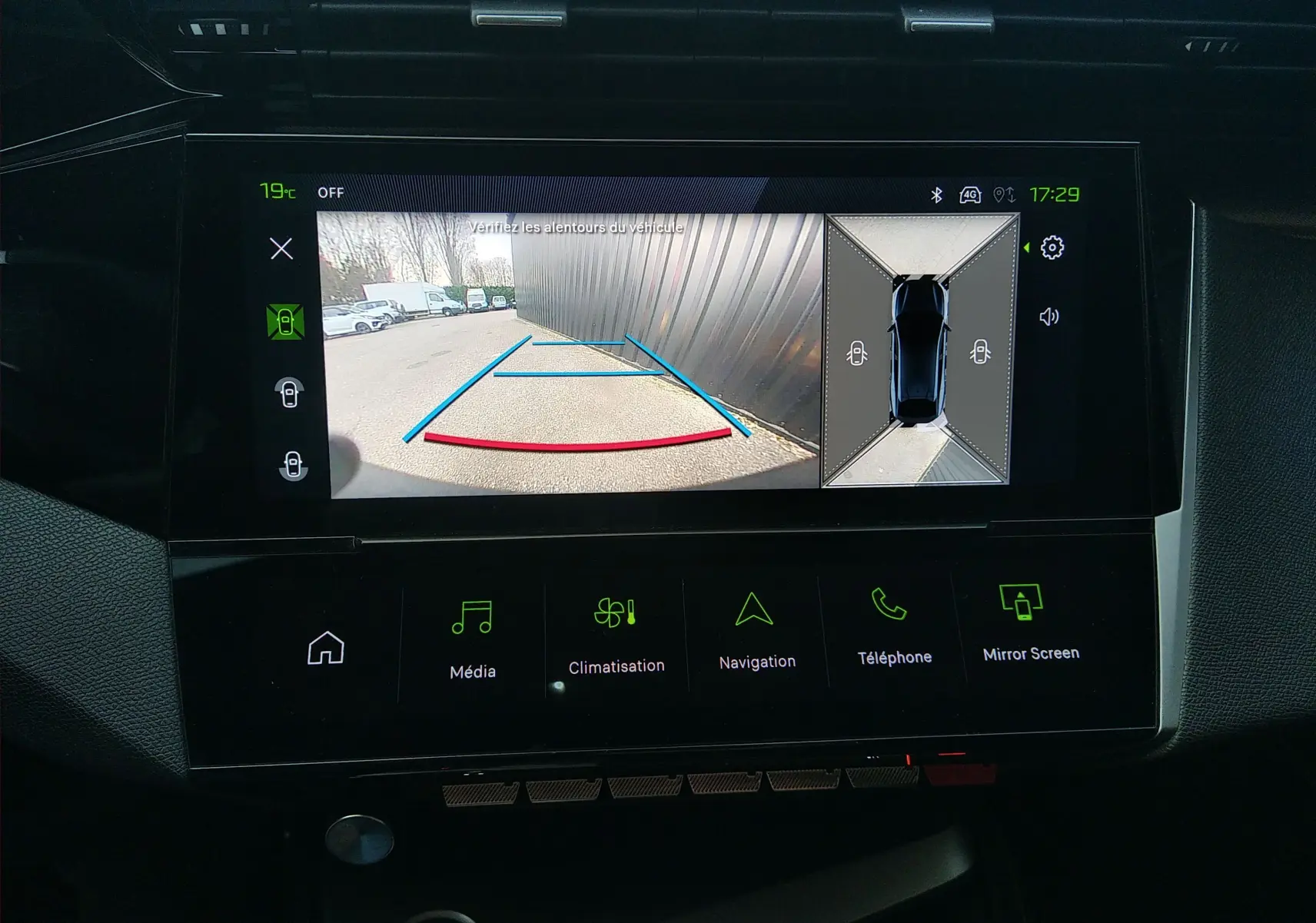 Écran tactile intérieur de la Peugeot 408 Hybrid blanc, affichant la caméra de recul avec vue 360° et guidage de trajectoire.