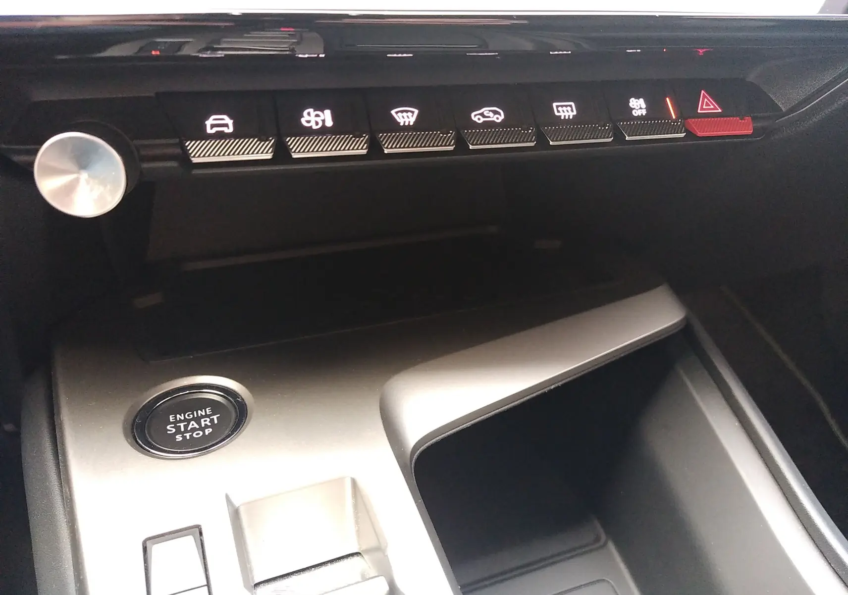 Vue rapprochée de la console centrale de la Peugeot 408 Hybrid 136ch GT, avec bouton start/stop et rangements argentés.