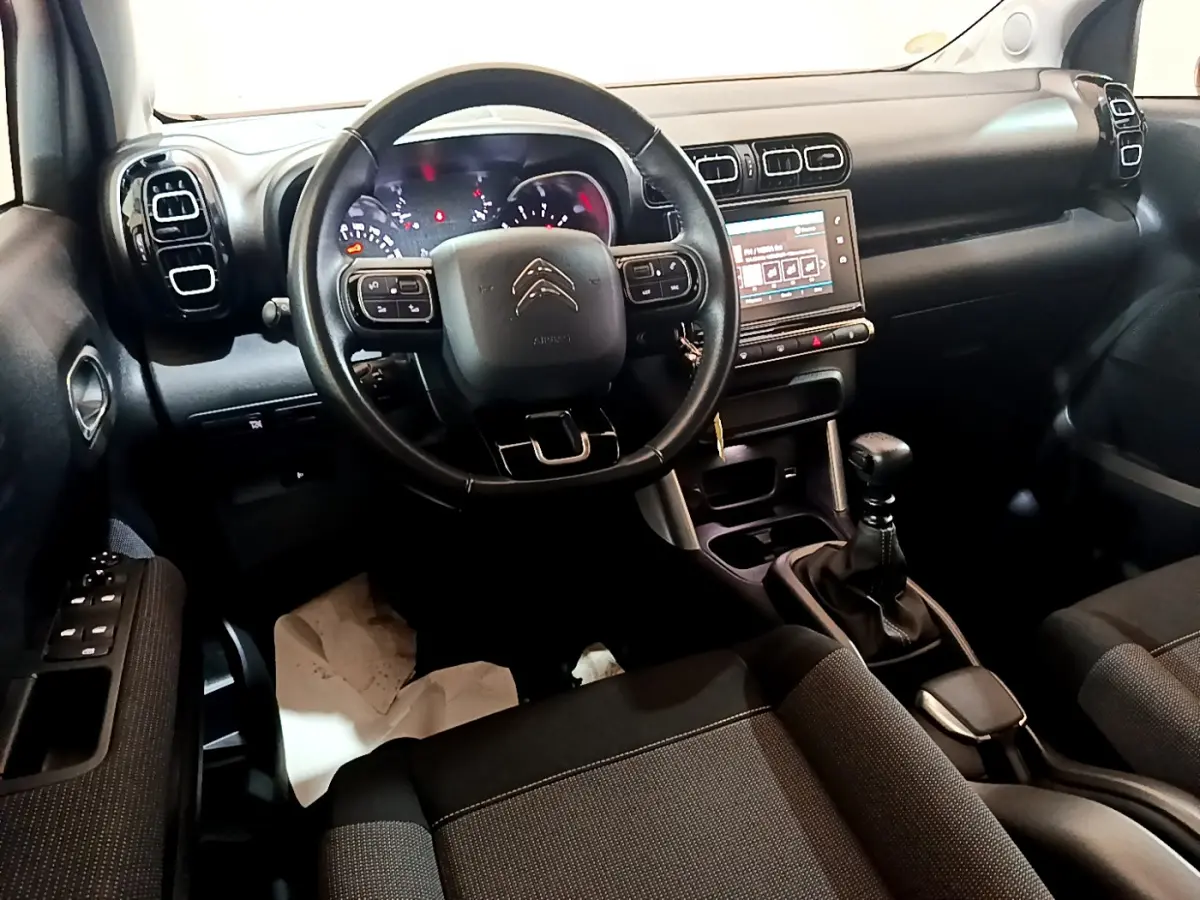 Intérieur noir du Citroën C3 Aircross 2019, vue du poste de conduite avec volant multifonctions et écran tactile central.