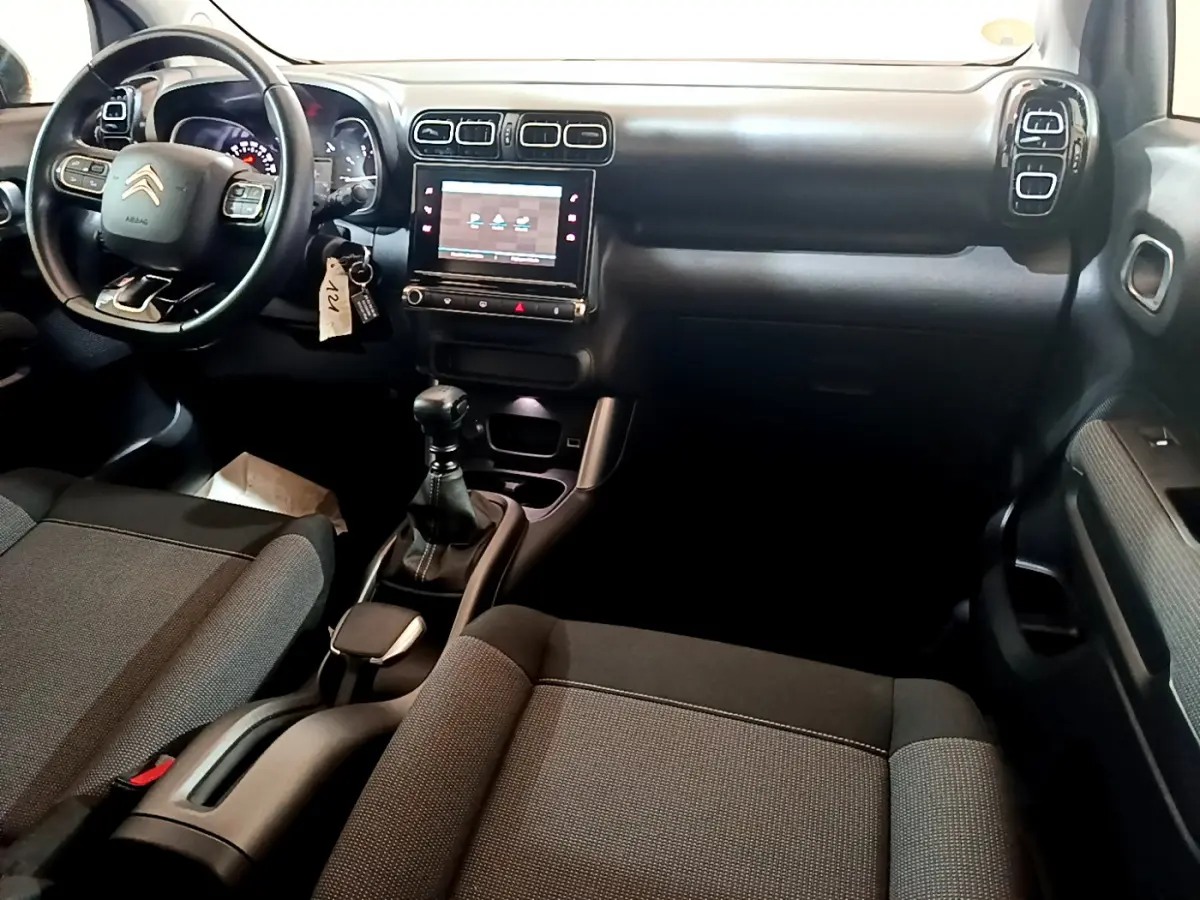 Intérieur noir du Citroën C3 Aircross 2019, vue du tableau de bord et volant côté conducteur avec écran tactile central.