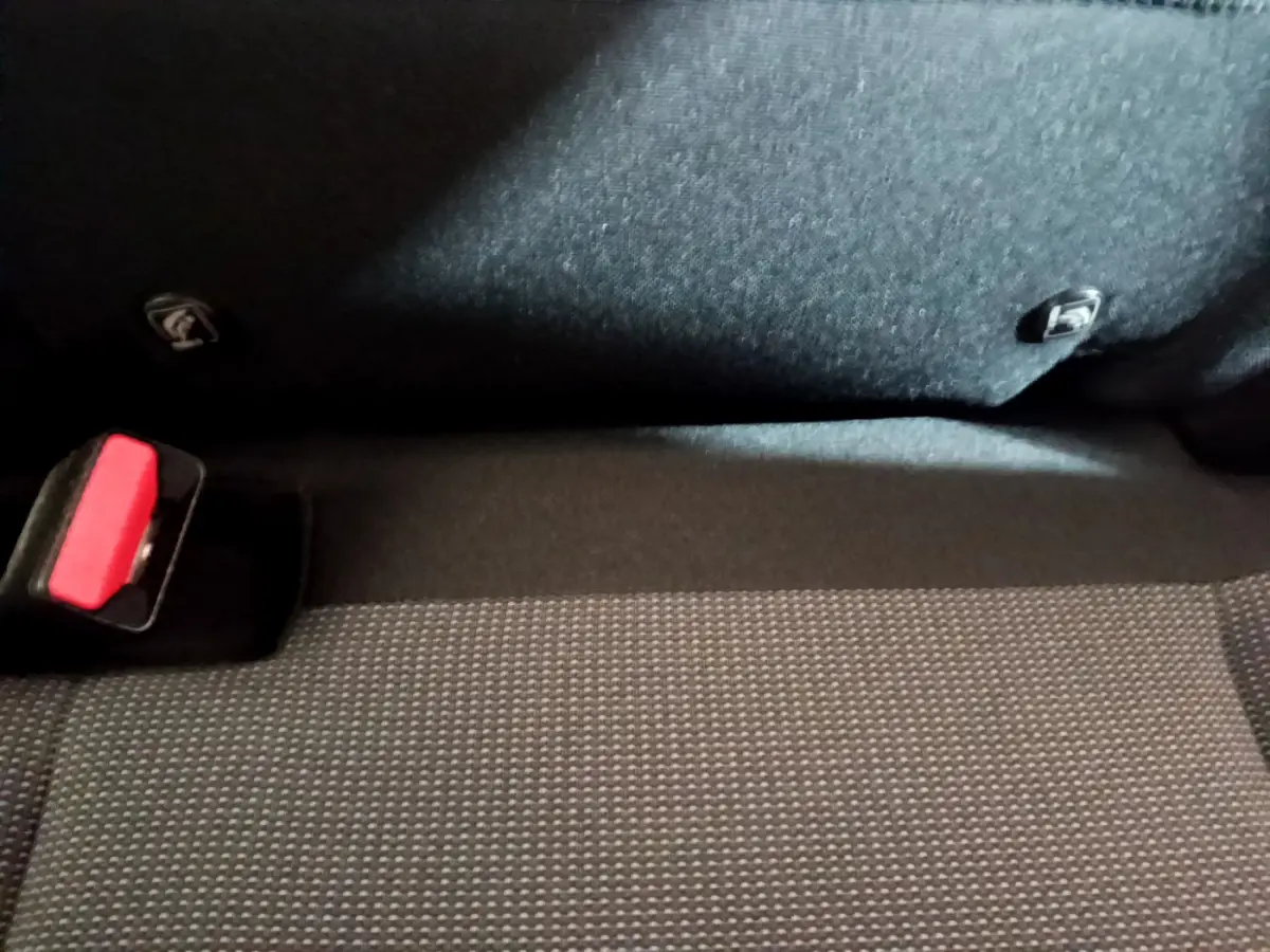 Gros plan sur la banquette arrière noire et la ceinture de sécurité rouge d'une Citroën C3 Aircross blanche.