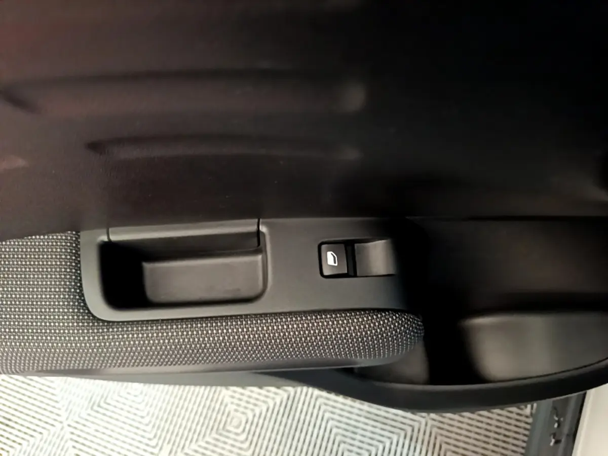Poignée intérieure et commande de lève-vitre côté gauche d'une Citroën C3 Aircross blanche, finition Feel Business.