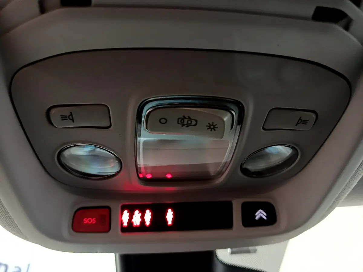 Plafonnier intérieur avec commandes d’éclairage et bouton SOS du Citroën C3 Aircross blanc, vue en contre-plongée.