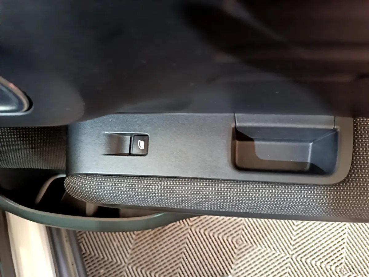 Gros plan sur la commande de lève-vitre côté conducteur dans l'intérieur noir du Citroën C3 Aircross blanc.