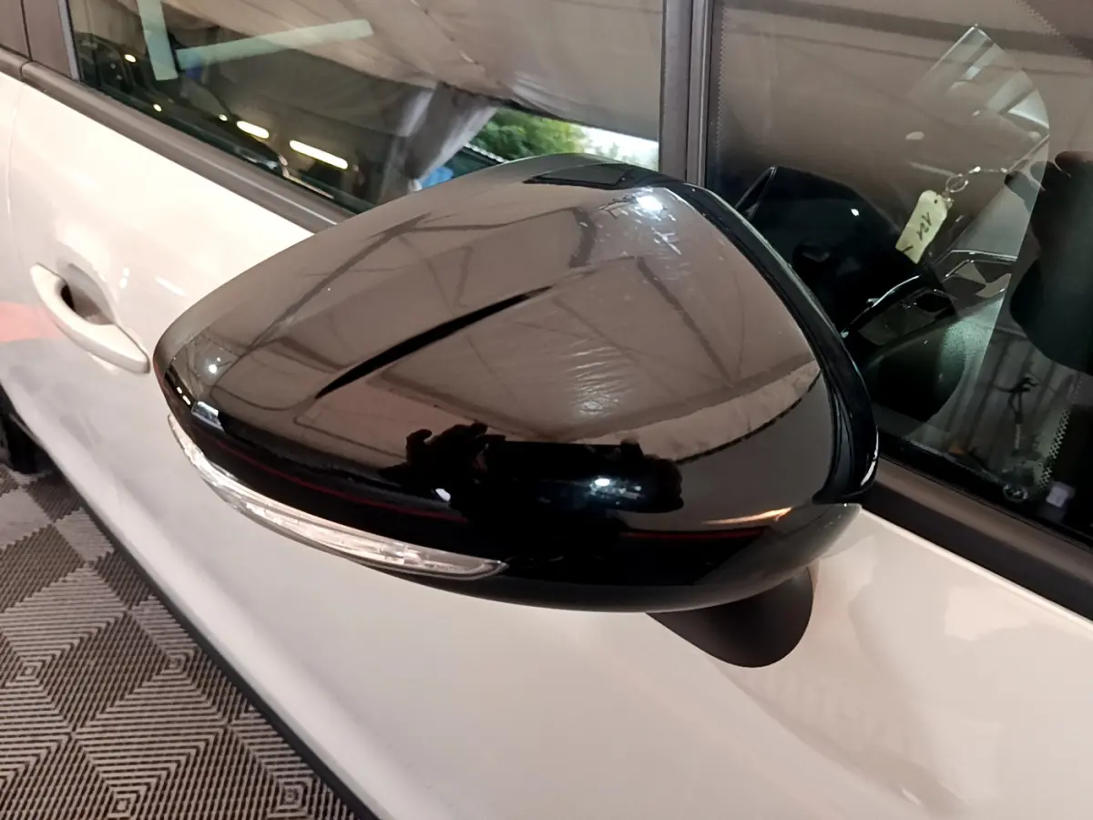 Rétroviseur noir brillant côté gauche du Citroën C3 Aircross blanc, avec clignotant intégré visible en gros plan.