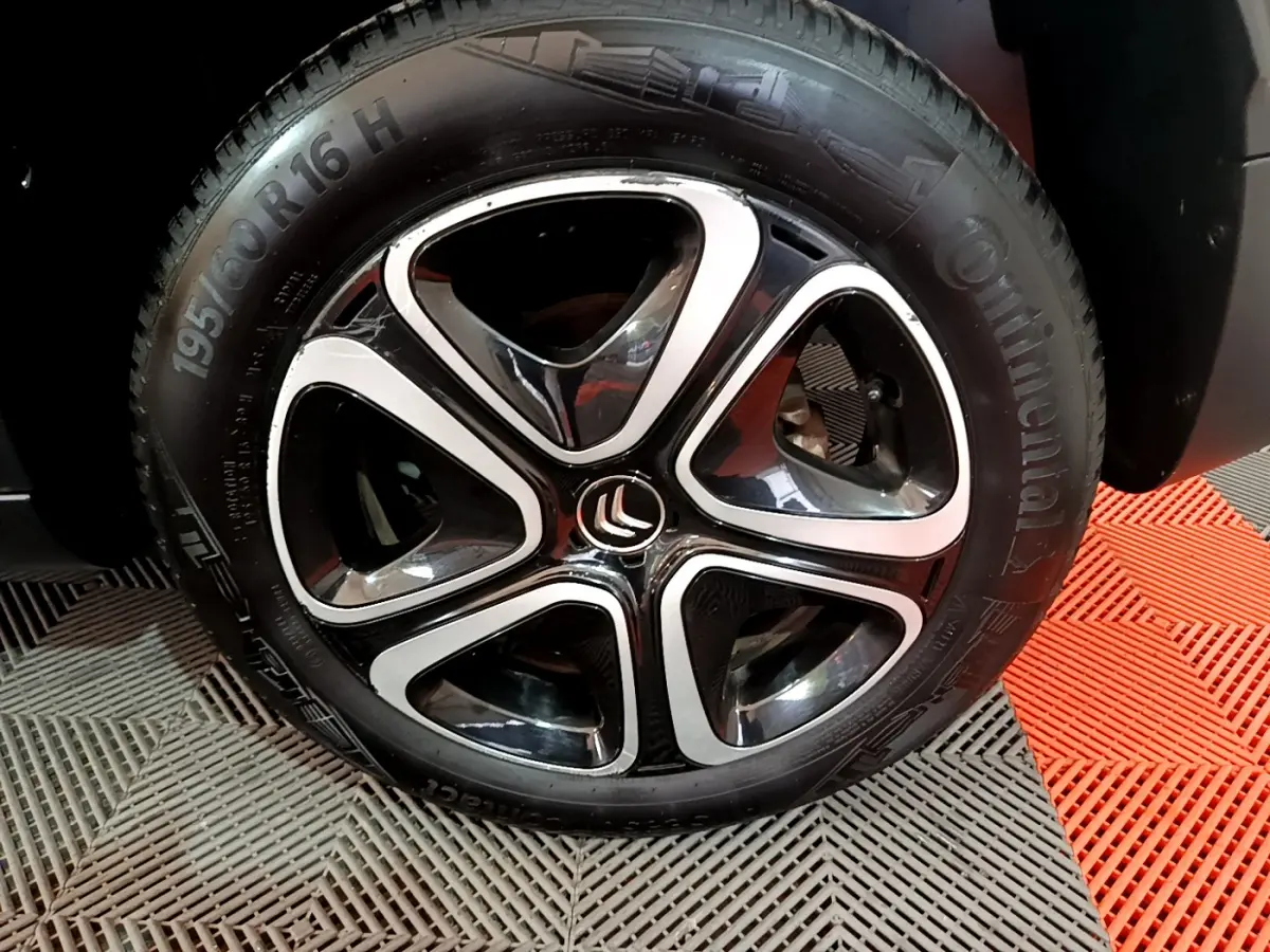 Gros plan sur la jante noire et argentée d'une Citroën C3 Aircross blanche, pneu Continental visible.