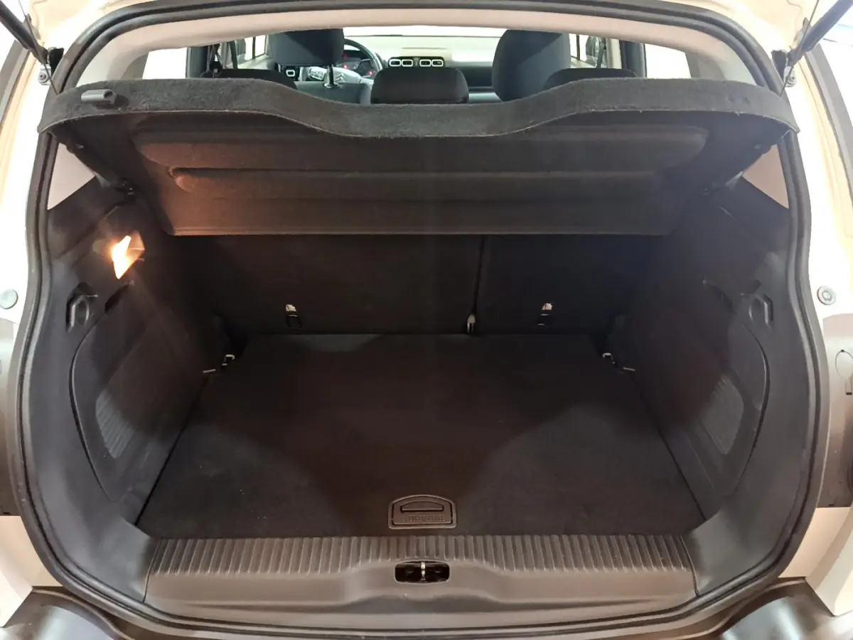 Coffre ouvert vu de l'arrière d'un Citroën C3 Aircross blanc, montrant un espace de chargement propre et spacieux.