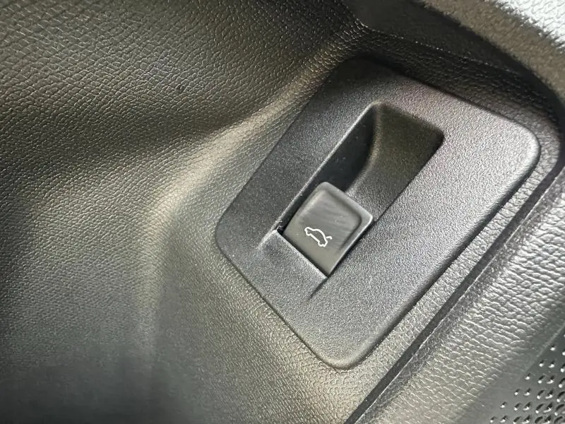 Bouton d'ouverture du coffre en plastique noir dans l'habitacle d'un CUPRA Formentor gris 2025.