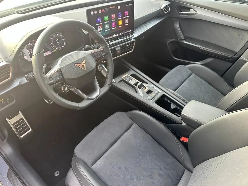 Intérieur du CUPRA Formentor 2025 vu côté conducteur, tableau de bord numérique et sellerie noire en tissu et cuir.