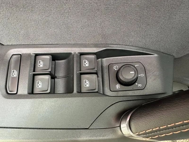 Gros plan sur les commandes des vitres et rétroviseurs côté conducteur d'une CUPRA Formentor gris 2025.