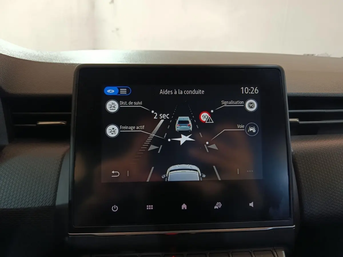 Écran tactile central de la Renault Clio gris clair 2023 affichant les aides à la conduite.