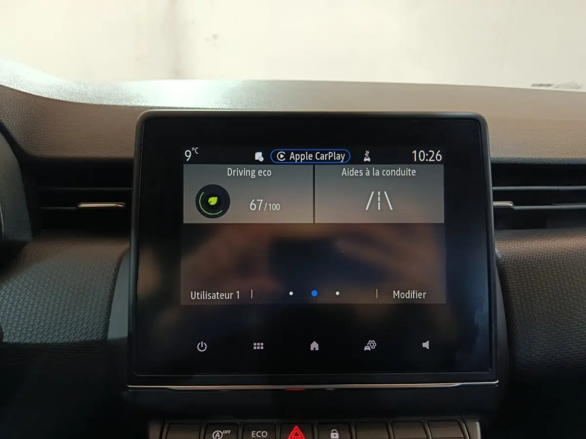 Écran tactile central de la Renault Clio gris clair, vue frontale du tableau de bord avec affichage Apple CarPlay.