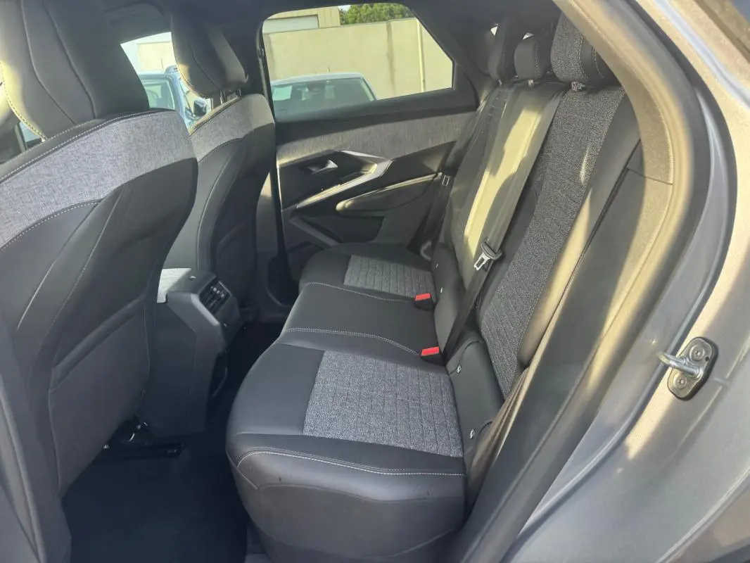 Vue intérieure arrière droite du Peugeot 3008 Hybrid 145 e-DCS6 Allure gris, sièges bicolores tissu et cuir.