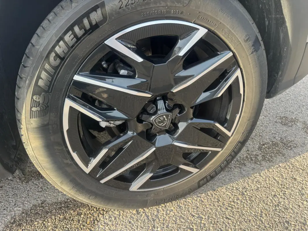 Gros plan sur la jante alliage noire et argentée de 19 pouces du Peugeot 3008 Hybrid 145 e-DCS6 Allure gris.