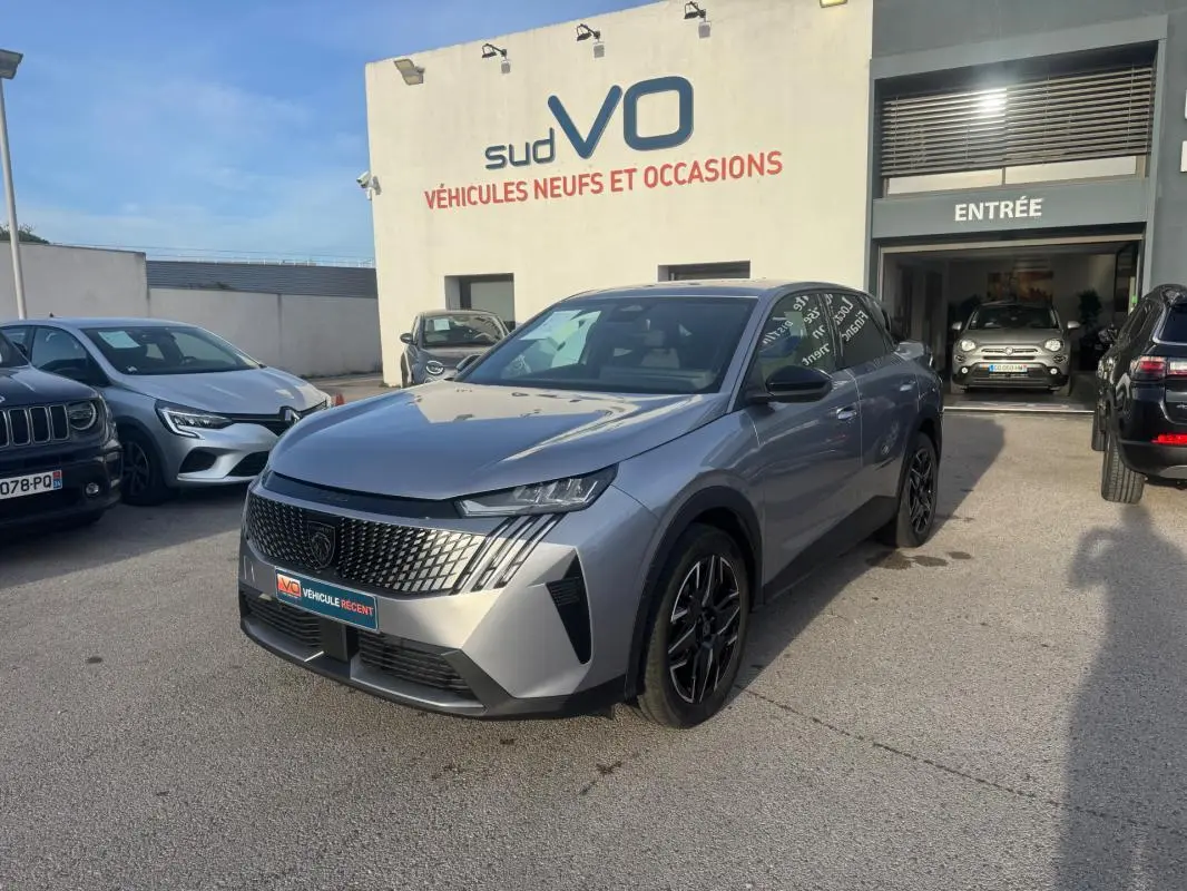 Peugeot 3008 Hybrid gris en 3/4 avant droit, avec calandre distinctive et jantes alliage noires de 19 pouces.