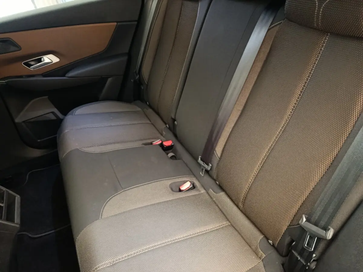 Vue rapprochée de la banquette arrière en tissu gris foncé du DS7 Crossback E-TENSE 225 BUSINESS, avec ceinture de sécurité visible.