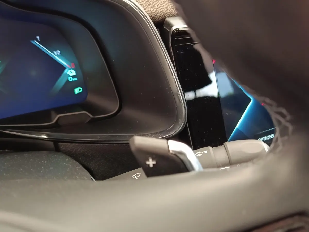 Gros plan sur le tableau de bord et le volant cuir multifonctions du DS7 Crossback E-TENSE 225 gris clair, affichage digital visible.