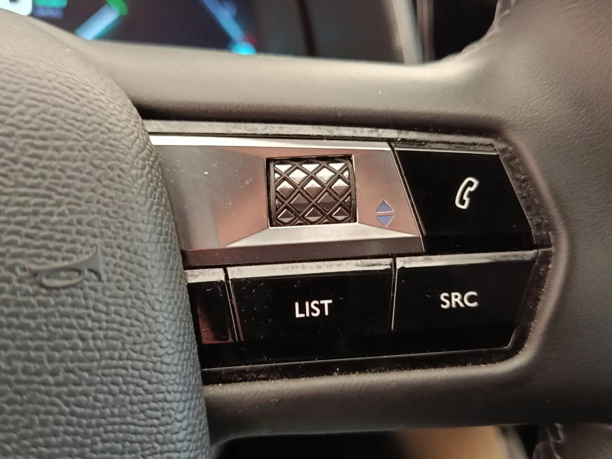 Gros plan sur les commandes multifonctions du volant cuir noir d'un DS7 Crossback E-TENSE 225 BUSINESS.