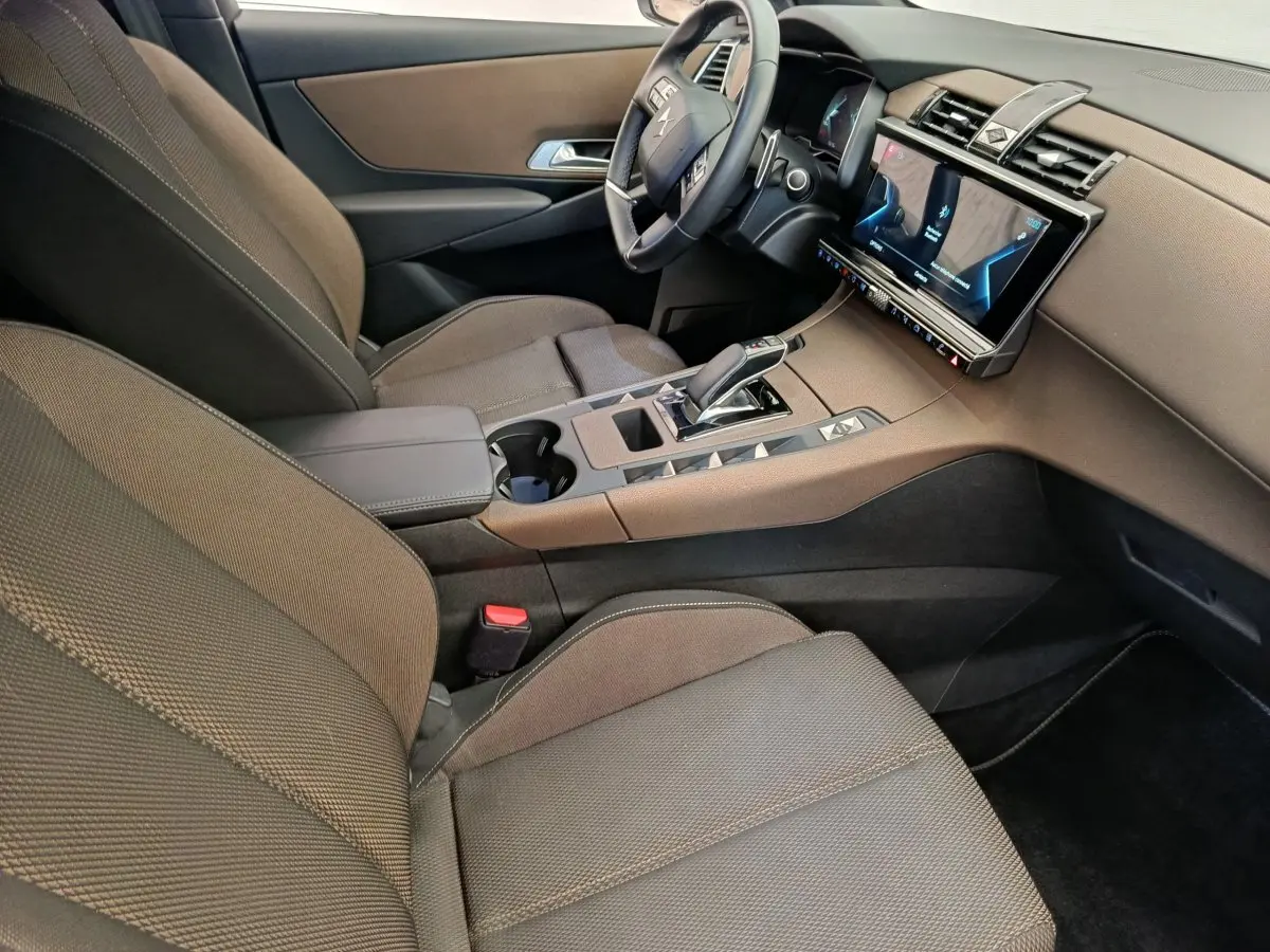 Vue intérieure côté conducteur du DS7 Crossback E-TENSE 225 Business, montrant sièges marron et console centrale avec écran tactile.