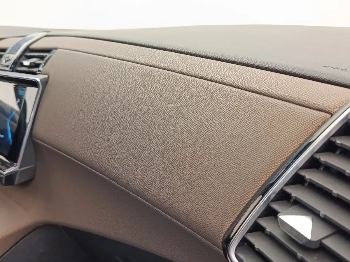 Détail de la planche de bord en cuir marron du DS7 Crossback E-TENSE 225 BUSINESS, avec sortie d’air chromée.